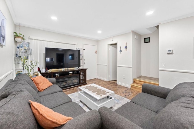 living room featuring recessed lighting, baseboards, wood finished floors, and crown molding