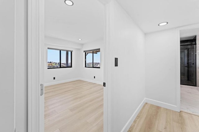 corridor featuring recessed lighting, baseboards, and light wood-style floors