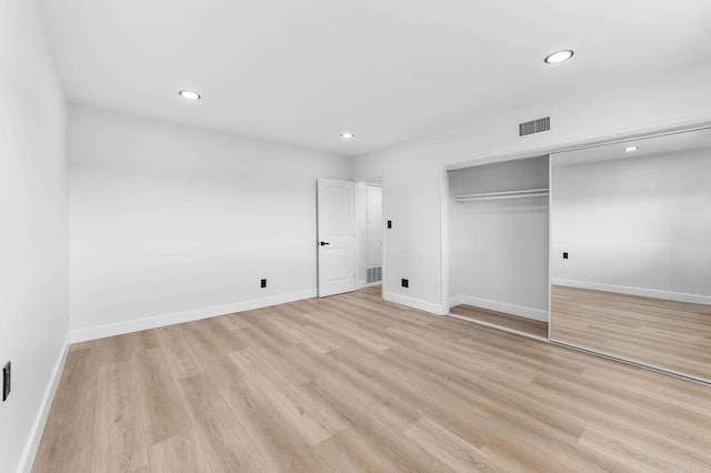 unfurnished bedroom with visible vents, recessed lighting, a closet, light wood finished floors, and baseboards