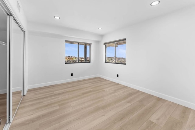 unfurnished bedroom featuring recessed lighting, baseboards, and light wood-type flooring