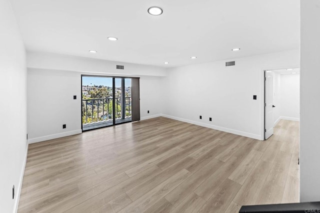 spare room with light wood finished floors, visible vents, recessed lighting, and baseboards