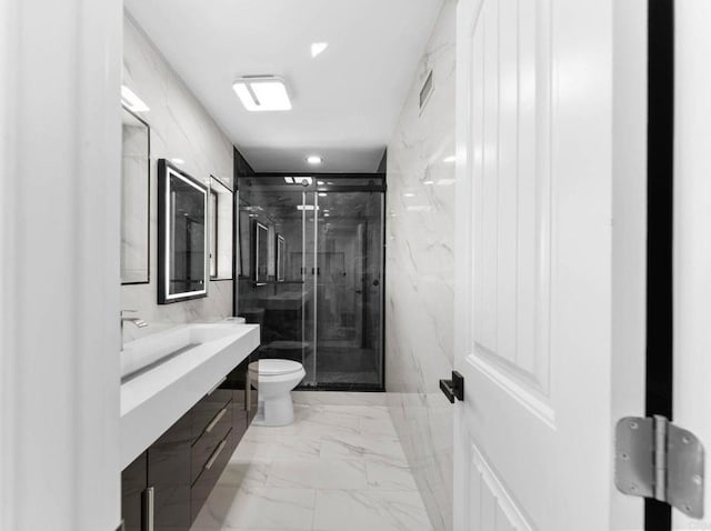 full bath featuring vanity, a marble finish shower, tile walls, toilet, and marble finish floor