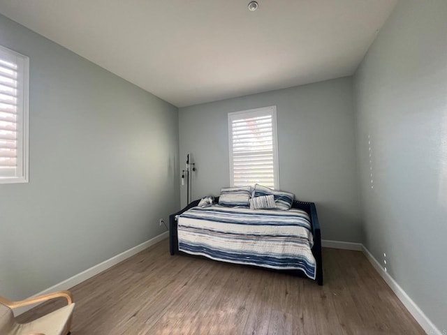 bedroom with baseboards and wood finished floors