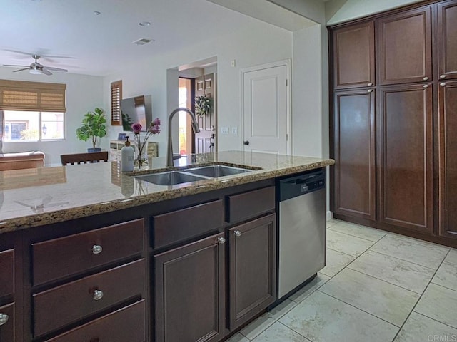 kitchen with light stone countertops, visible vents, a sink, dark brown cabinets, and stainless steel dishwasher