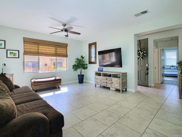 living room featuring a ceiling fan, a healthy amount of sunlight, visible vents, and baseboards