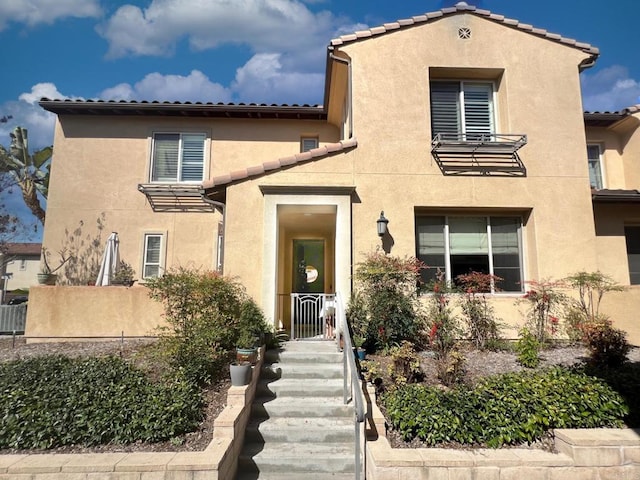 mediterranean / spanish-style home with stucco siding and a tile roof