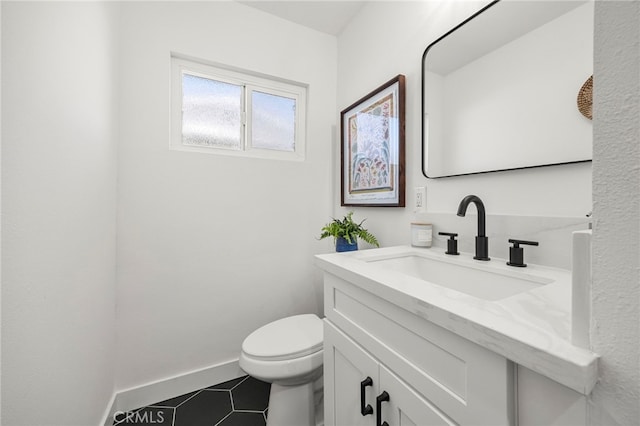 bathroom with tile patterned flooring, toilet, vanity, and baseboards