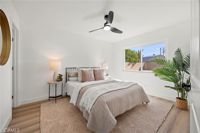 bedroom featuring a ceiling fan, wood finished floors, and baseboards