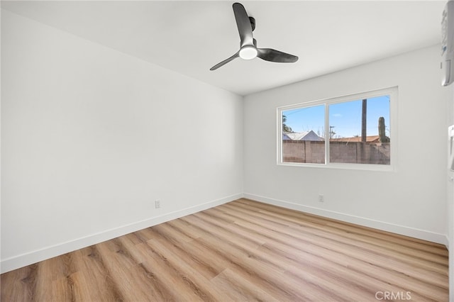 spare room with a ceiling fan, baseboards, and light wood finished floors