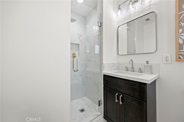 full bath featuring a marble finish shower, visible vents, and vanity