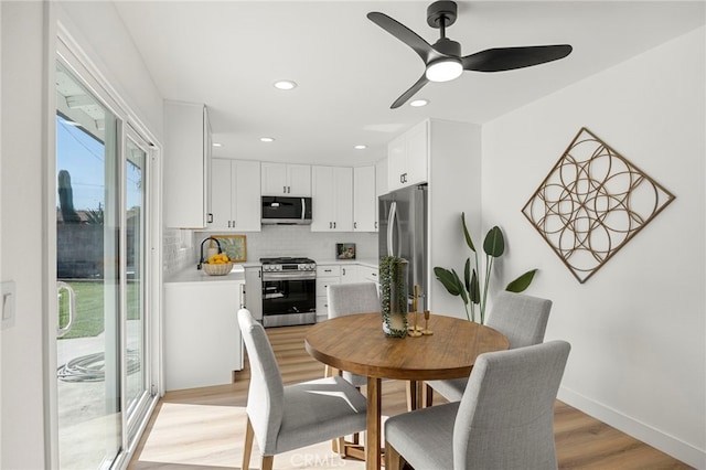 dining space featuring light wood-style flooring, recessed lighting, a ceiling fan, and baseboards