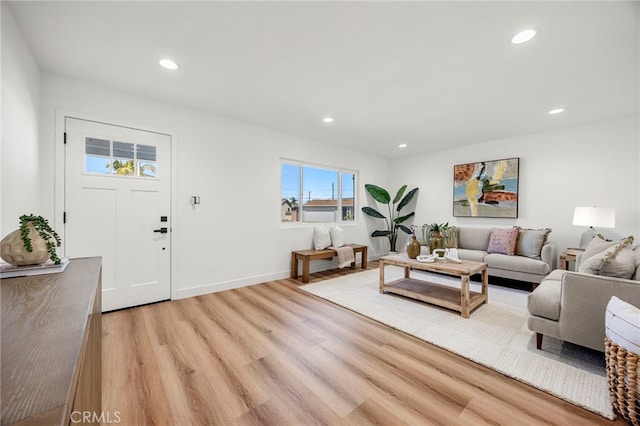 living room featuring recessed lighting, baseboards, and light wood-style flooring