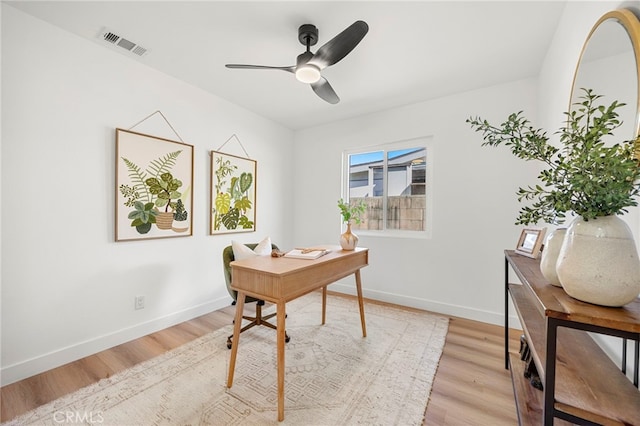 office area with light wood-type flooring, visible vents, and baseboards