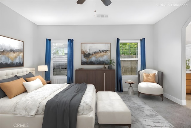 carpeted bedroom with a ceiling fan, multiple windows, baseboards, and visible vents