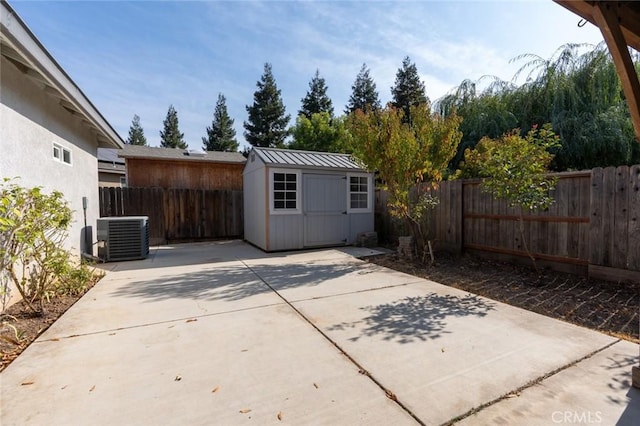 view of patio featuring a storage shed, an outbuilding, cooling unit, and a fenced backyard