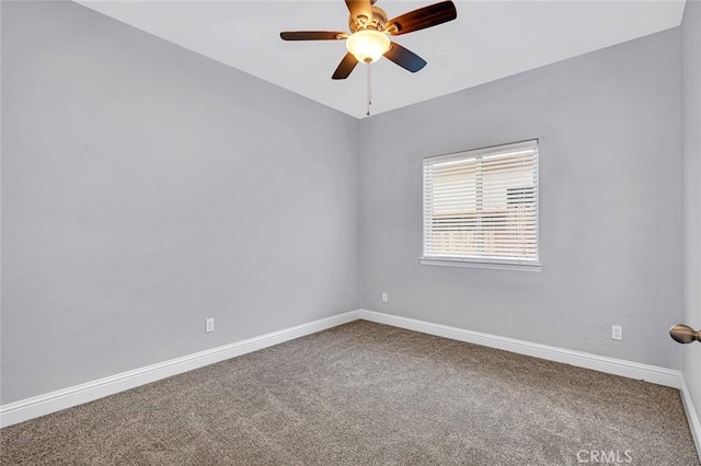 carpeted spare room with a ceiling fan and baseboards