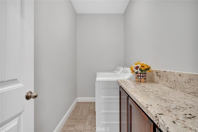 bathroom featuring separate washer and dryer and baseboards