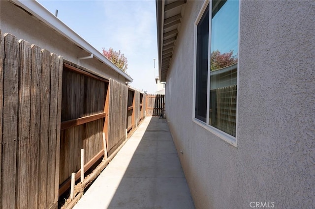 view of home's exterior with stucco siding and fence