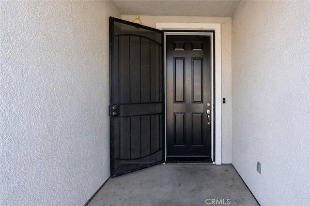 view of exterior entry featuring stucco siding