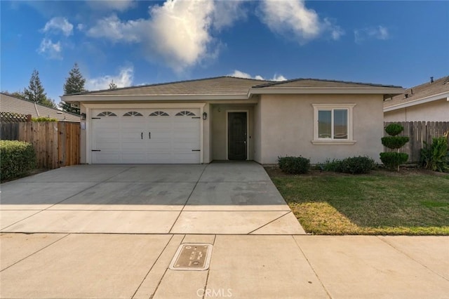 ranch-style home with a front yard, fence, an attached garage, stucco siding, and concrete driveway