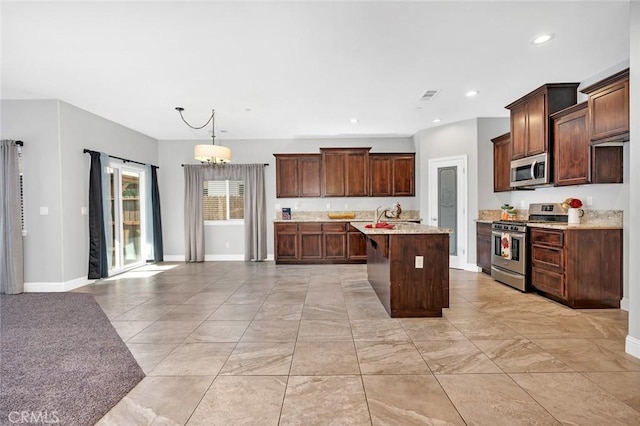 kitchen featuring baseboards, visible vents, an island with sink, recessed lighting, and stainless steel appliances