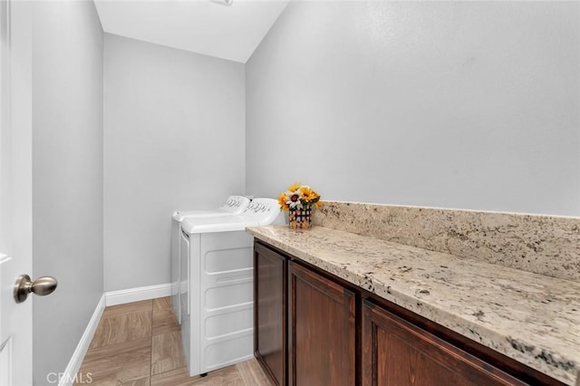 bathroom with washer and clothes dryer and baseboards