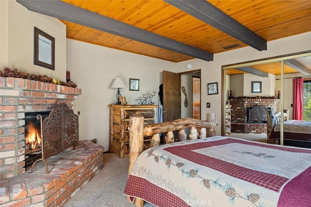 carpeted bedroom with beam ceiling, visible vents, a fireplace, and wooden ceiling