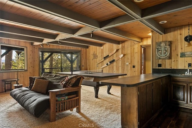 recreation room with beamed ceiling, dark carpet, wooden ceiling, and wooden walls