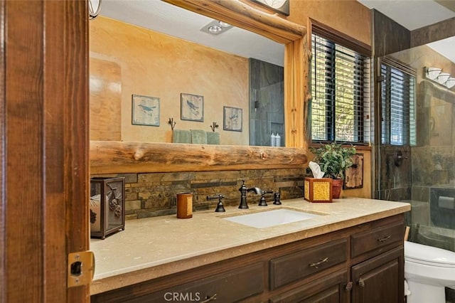 bathroom with vanity, toilet, a shower stall, and tasteful backsplash