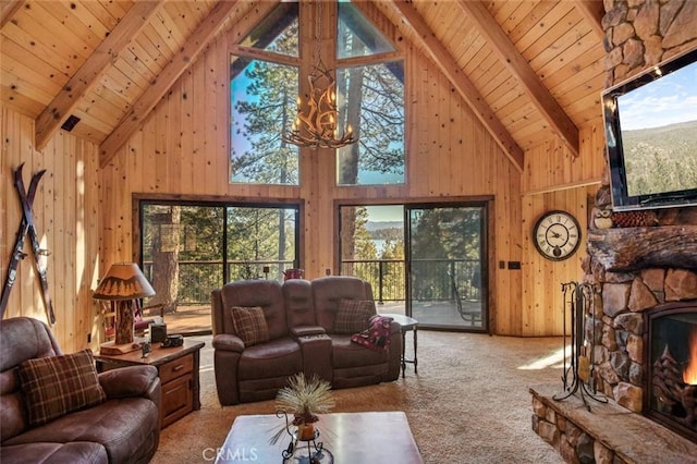 carpeted living room featuring a stone fireplace, beam ceiling, wooden walls, and wood ceiling