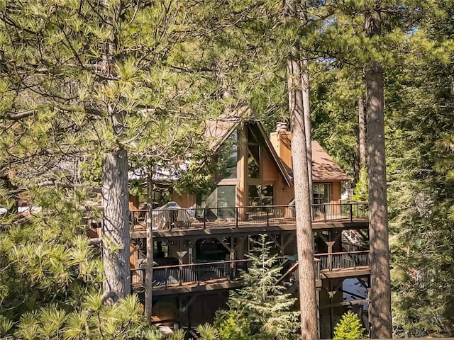 rear view of house with a deck and a chimney