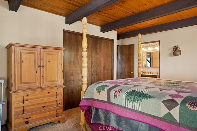 carpeted bedroom featuring ensuite bath, beam ceiling, and wood ceiling