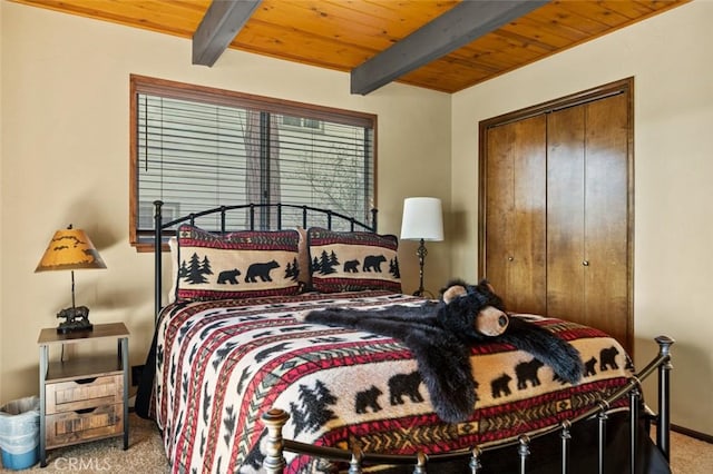 bedroom with beam ceiling, wood ceiling, and carpet floors