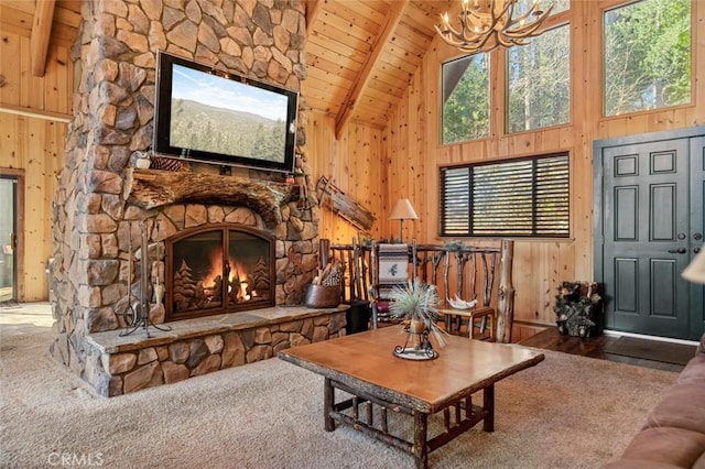 carpeted living area with high vaulted ceiling, a fireplace, wood walls, wooden ceiling, and beamed ceiling