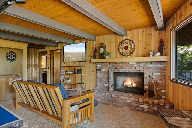 carpeted living area with beam ceiling, wood walls, a fireplace, and wooden ceiling