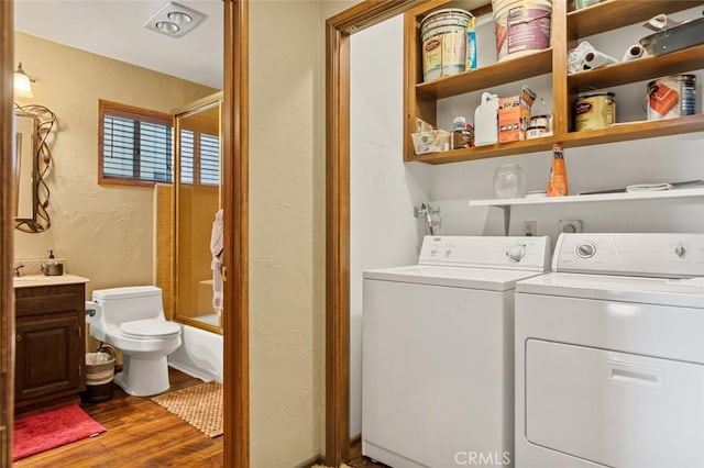 laundry area featuring washer and dryer, laundry area, dark wood-style flooring, and a textured wall