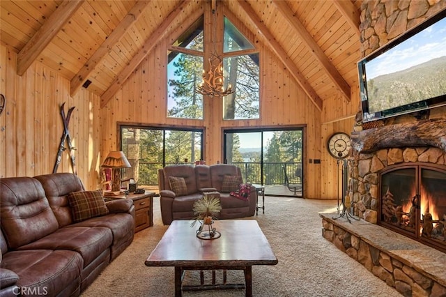 living room featuring beamed ceiling, wooden walls, a fireplace, and carpet flooring