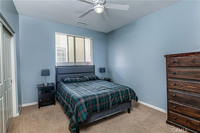 bedroom featuring visible vents, baseboards, a textured ceiling, and carpet flooring