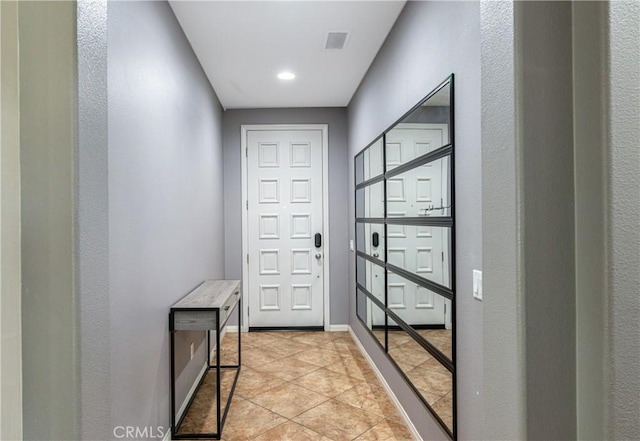 entryway with light tile patterned floors, visible vents, and baseboards