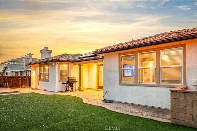 back of property with a chimney, a patio area, fence, and stucco siding