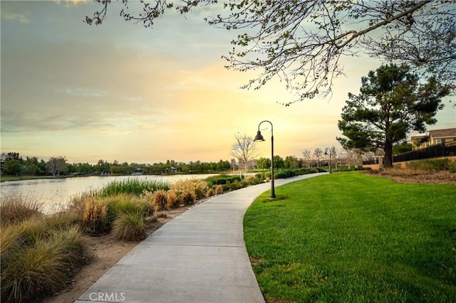 surrounding community with a yard and a water view