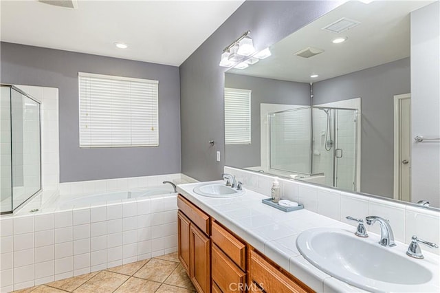 bathroom with a shower stall, a bath, tile patterned floors, and a sink