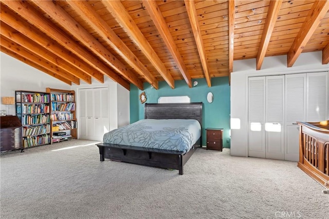 bedroom with lofted ceiling with beams, wood ceiling, and carpet floors