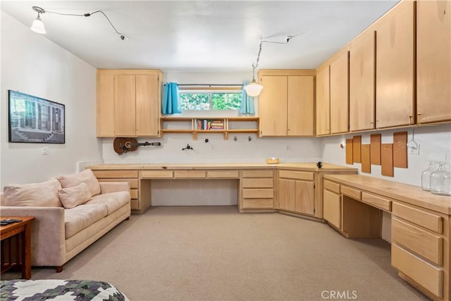 kitchen with light brown cabinetry, built in study area, and light countertops