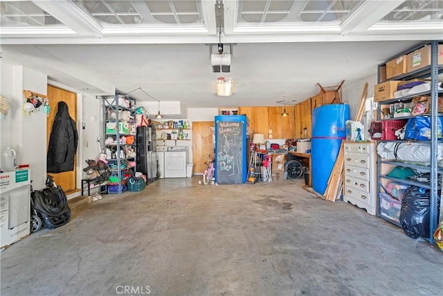 garage with fridge with ice dispenser, independent washer and dryer, and a garage door opener