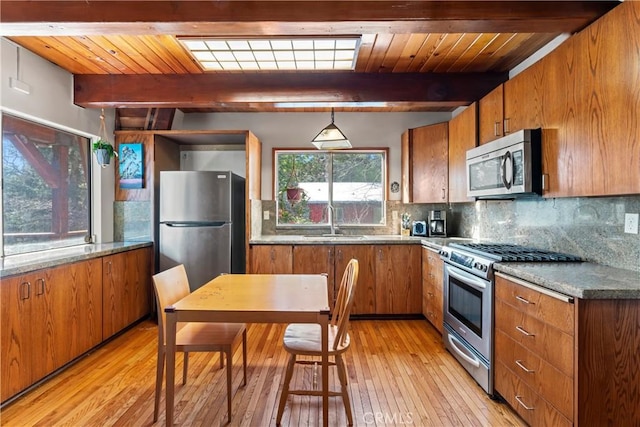 kitchen with a sink, brown cabinets, backsplash, and appliances with stainless steel finishes