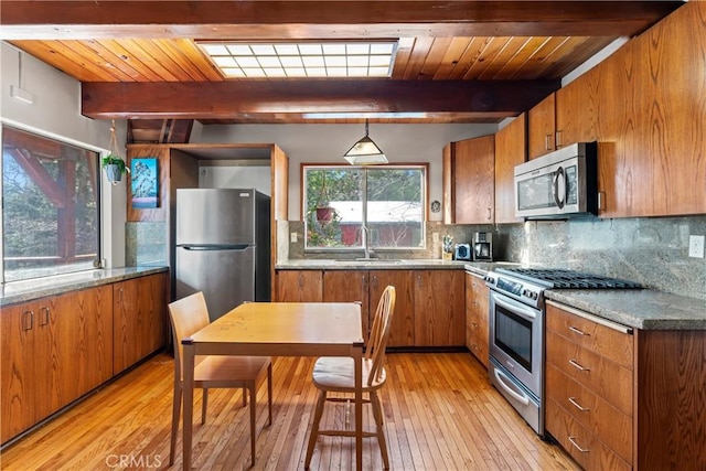 26509 Lake Forest Dr, Twin Peaks, CA 92391 - kitchen featuring beam ceiling, brown cabinetry, appliances with stainless steel finishes, and a sink