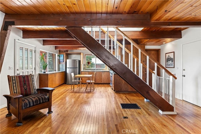 interior space featuring beamed ceiling, wood-type flooring, visible vents, and wooden ceiling