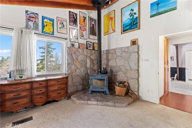 interior space featuring a wood stove, visible vents, and carpet floors