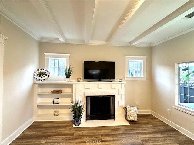 unfurnished living room with beamed ceiling, wood finished floors, and a healthy amount of sunlight